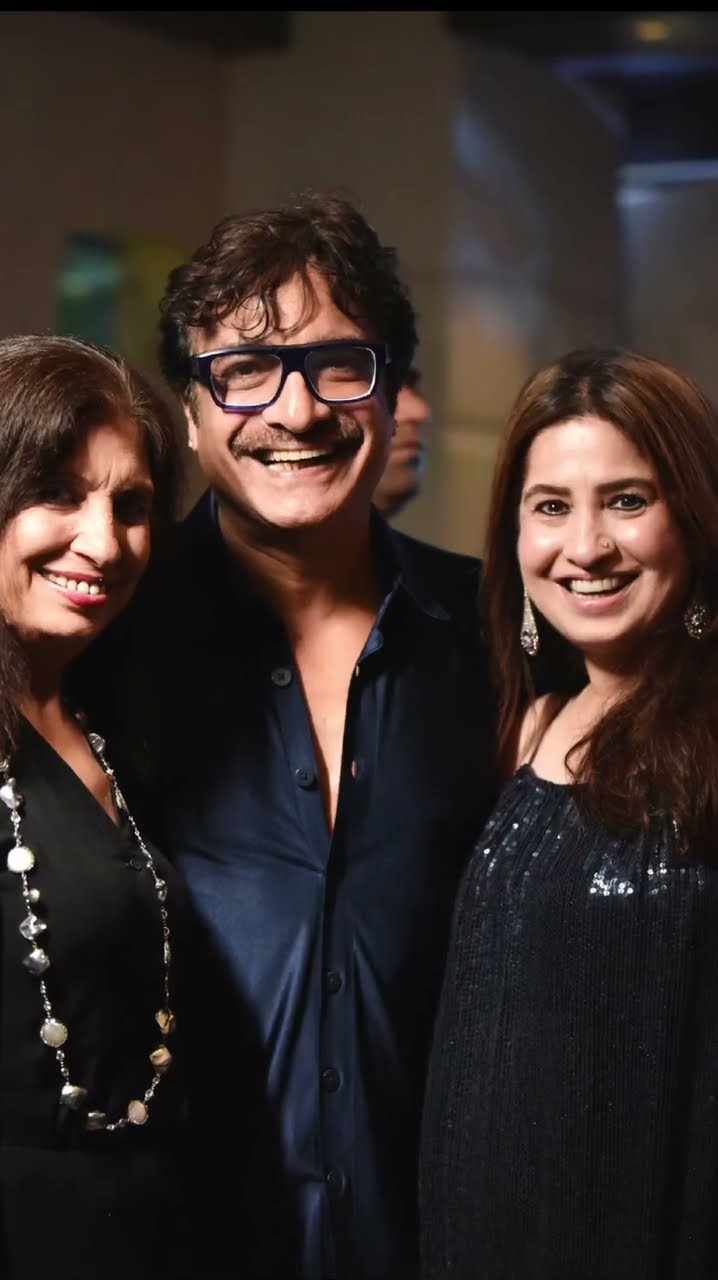 Three guests photographed together smiling at an evening event