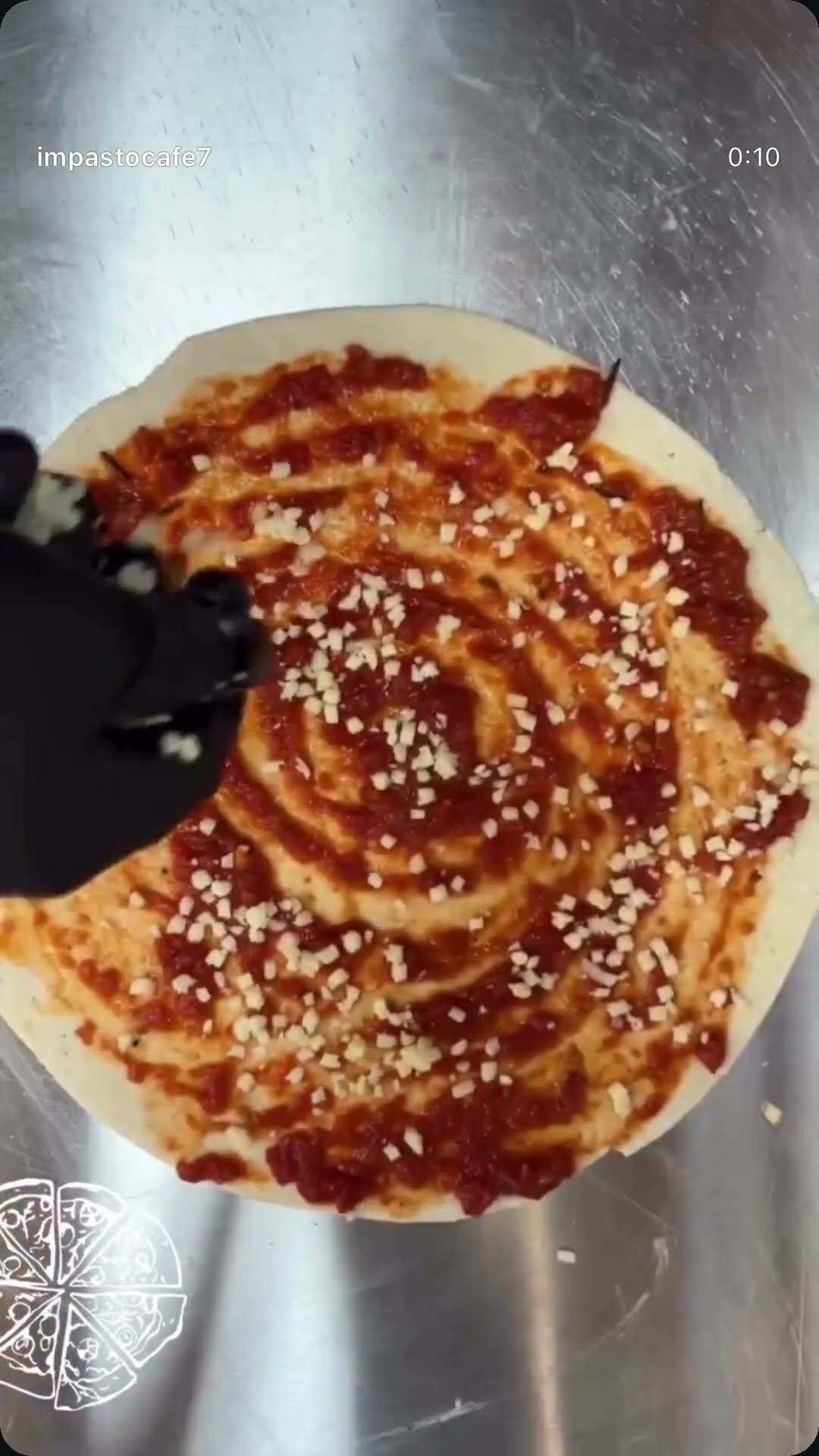 An overhead shot of a pizza being lifted from a tray