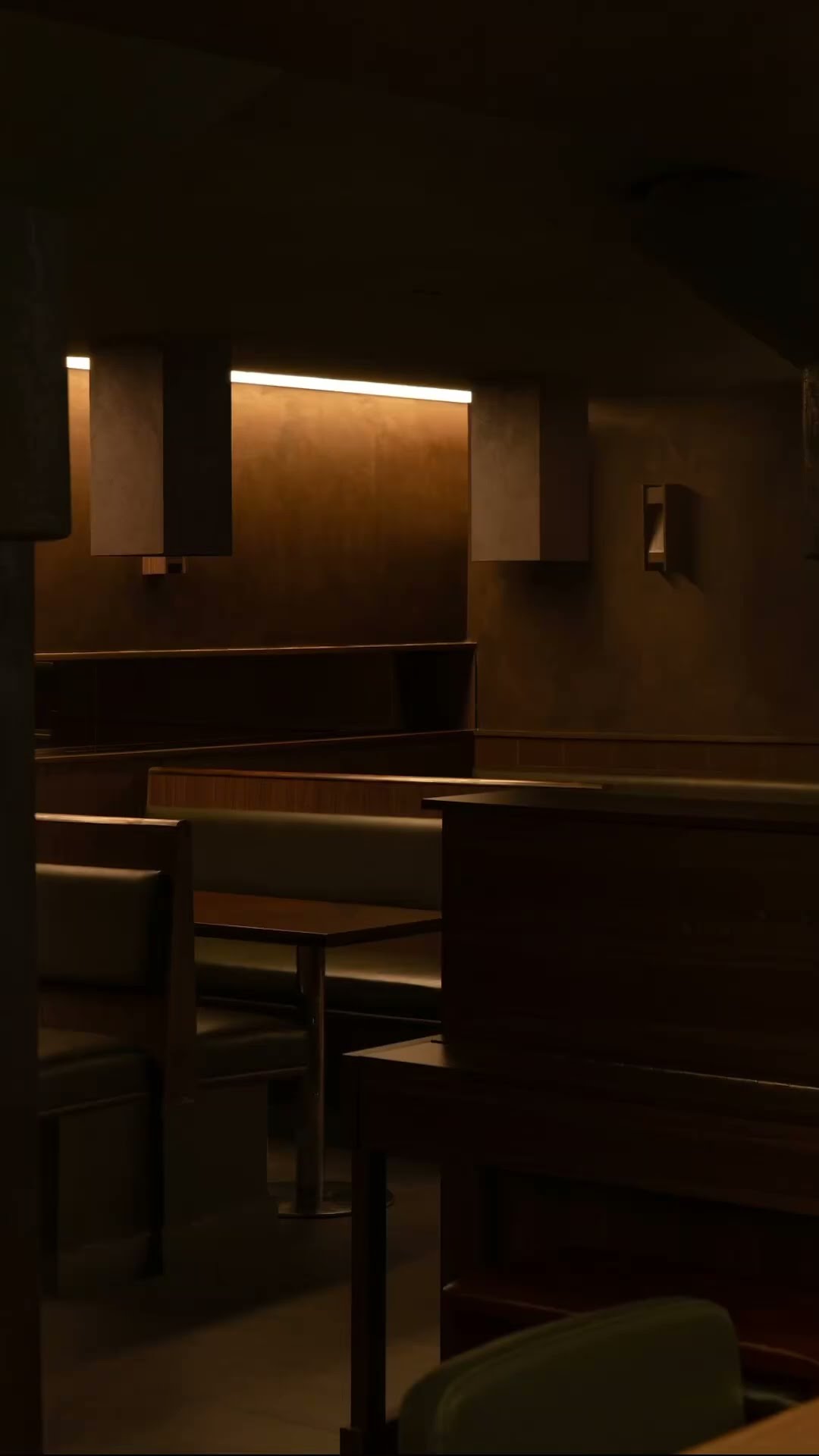A dim restaurant interior with a green upholstered chair