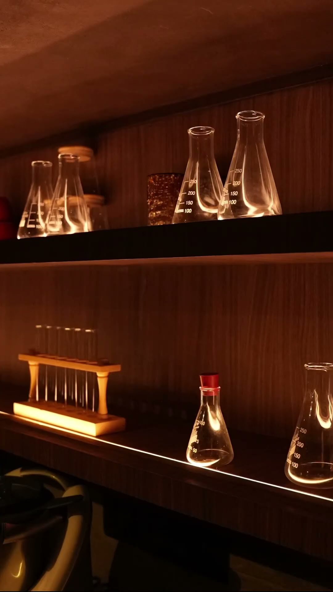 Glass carafes lined along a lit back-bar shelf