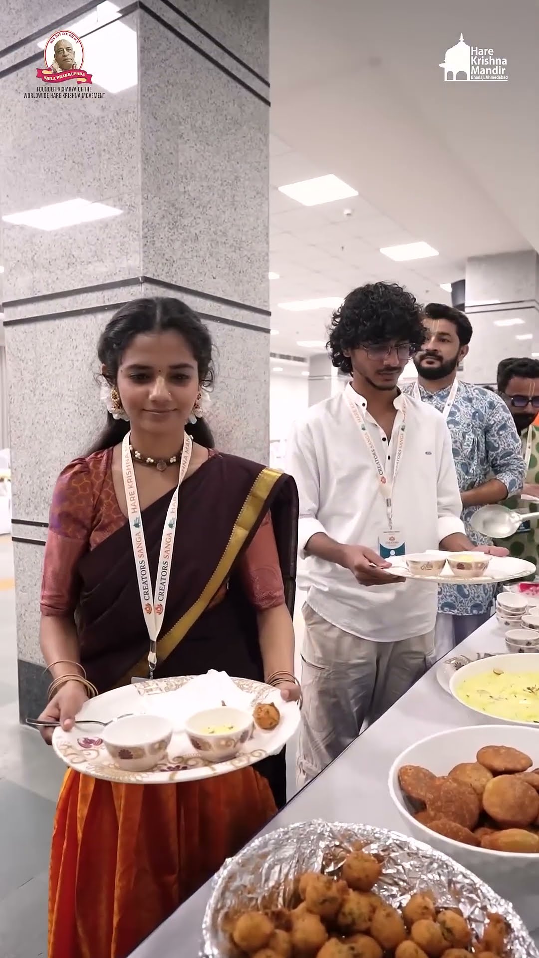 Guests being served plates of food at a catering counter during an event