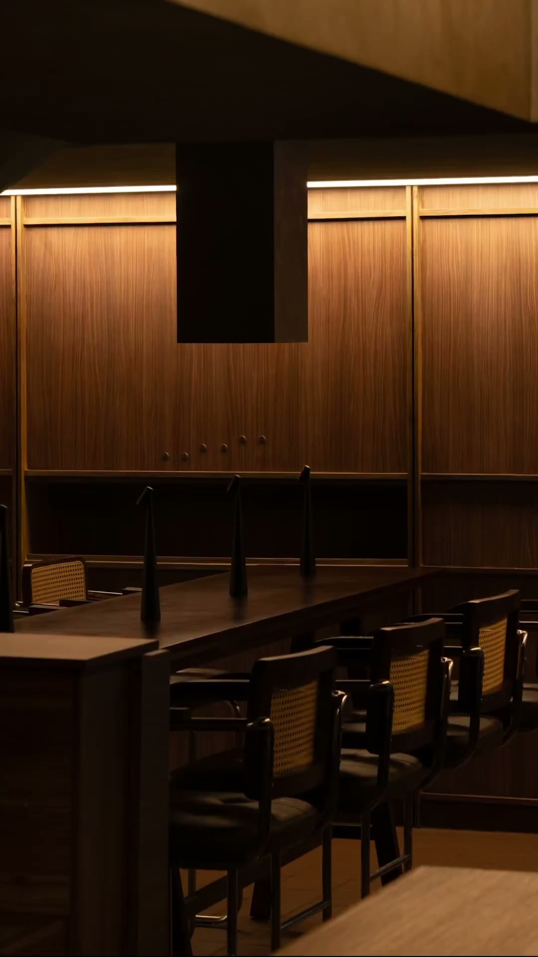An empty wood-panelled dining room lit for the evening